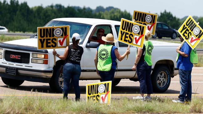 United Auto Workers members and their volunteers stand out alongside the access road to the Nissan vehicle assembly plant in Canton, Miss., and greet each arriving vehicle, Thursday, Aug. 3, 2017. Union members set up informational lines outside employee entrances at the plant and greeted all shifts of workers arriving and leaving, reminding workers to vote for the union. The vote for union representation of line workers runs Aug. 3-4. (AP Photo/Rogelio V. Solis)