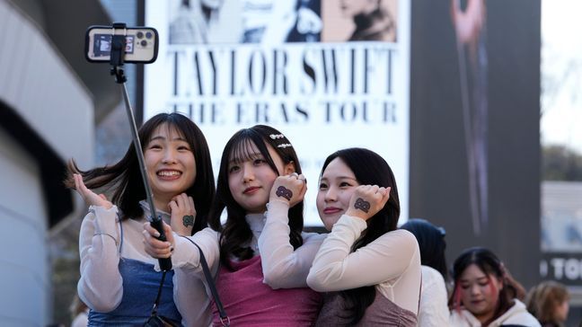 Women pose for a selfie before Taylor Swift's concert at Tokyo Dome in Tokyo, Saturday, Feb. 10, 2024. (AP Photo/Hiro Komae)