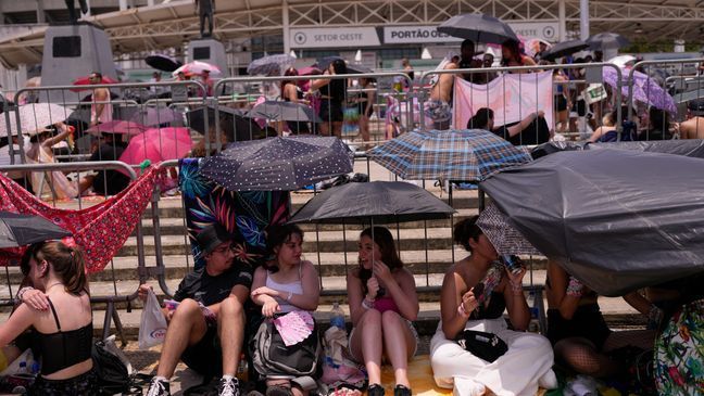 Taylor Swift fans wait for the doors of Nilton Santos Olympic stadium to open for her Eras Tour concert amid a heat wave in Rio de Janeiro, Brazil, Saturday, Nov. 18, 2023. (AP Photo/Silvia Izquierdo)