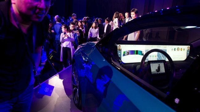 In this April 20, 2018, photo, a visitor looks at the large display panel of the BYTON electric concept car during a press event held ahead of the Auto China 2018 in Beijing, China. Auto China 2018, the biggest global auto show of the year, showcases China's ambitions to become a leader in electric cars and the industry's multibillion-dollar scramble to roll out models that appeal to price-conscious but demanding Chinese drivers. (AP Photo/Ng Han Guan)